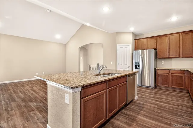 a kitchen with stainless steel appliances granite countertop a sink stove and refrigerator