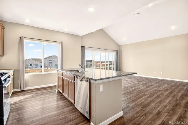 a kitchen with stainless steel appliances granite countertop a stove and a large window