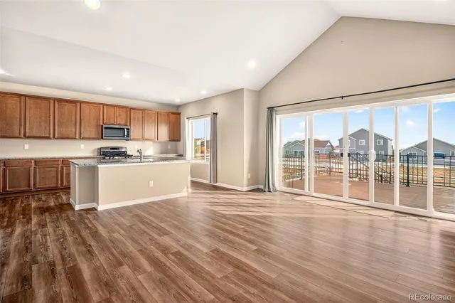 a kitchen with stainless steel appliances granite countertop a stove a sink and a refrigerator
