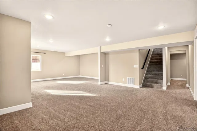 a view of an empty room with stairs and ventilation