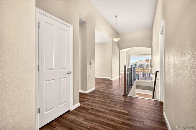 a view of a hallway with wooden floor table and chairs