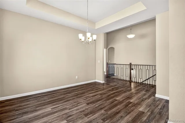a view of a hallway with wooden floor and a chandelier