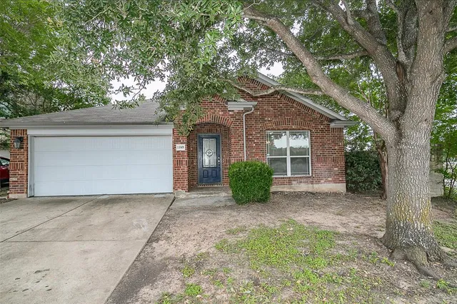 a view of a house with a tree in front of it
