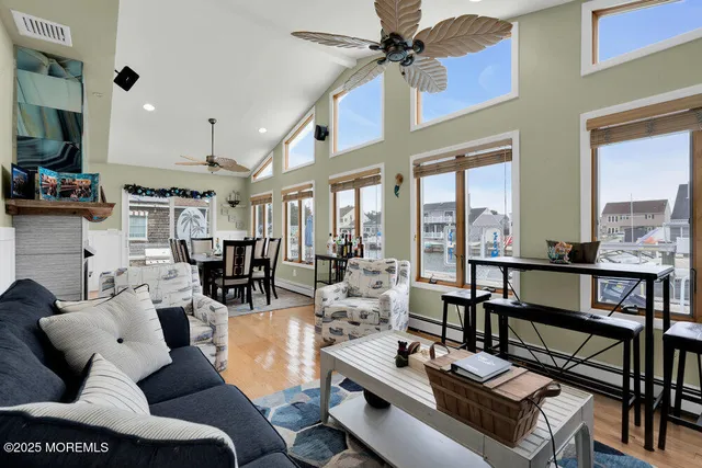 a living room with furniture a flat screen tv and a floor to ceiling window
