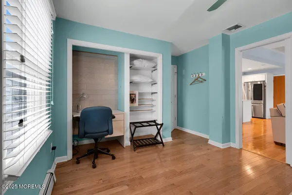 a view of a workspace with furniture and a window
