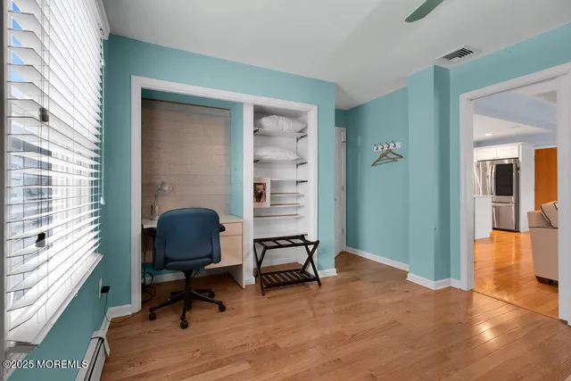 a view of a workspace with furniture and a window