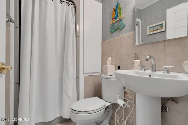 a bathroom with a sink a toilet and a mirror