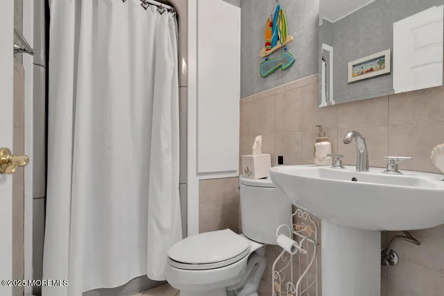 a bathroom with a sink a toilet and a mirror