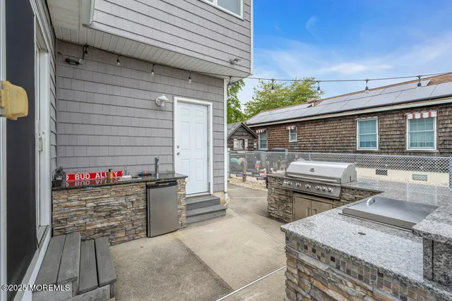 a view of a patio with table and chairs and barbeque