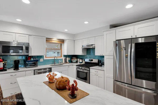 a kitchen with stainless steel appliances a refrigerator sink and microwave