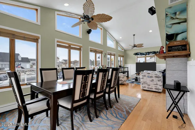 a view of a dining room with furniture a chandelier and wooden floor