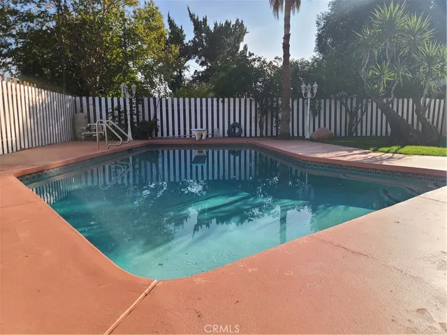 a view of a pathway of a white building with wooden fence