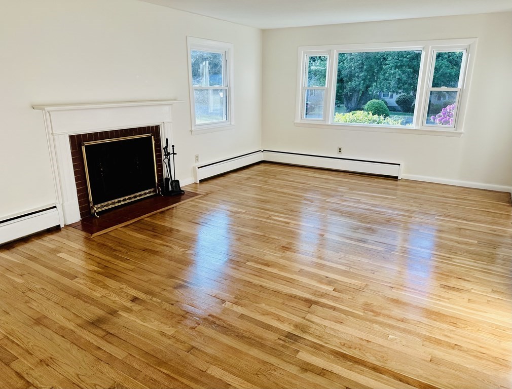 209 Birch Road Longmeadow, MA 01106 - Photo 3 of 13 an empty room with wooden floor and fireplace