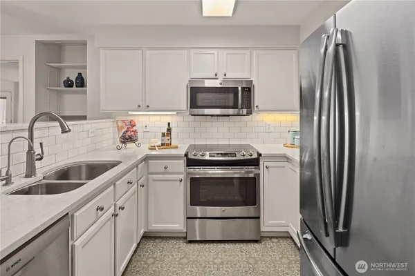 a kitchen with stainless steel appliances a stove a sink and a refrigerator
