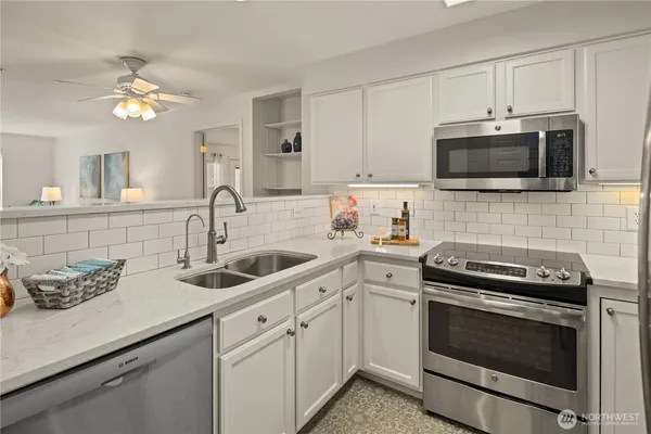 a kitchen with cabinets stainless steel appliances a sink and a microwave