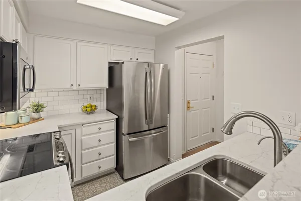 a kitchen with granite countertop a refrigerator and a sink