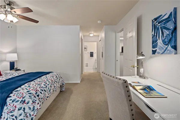 a bedroom with a bed and a lamp on the dresser