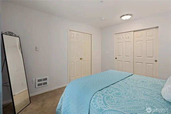 a bedroom with a bed and a mirror