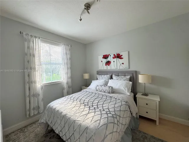 a bedroom with a bed and a flat tv screen on dresser