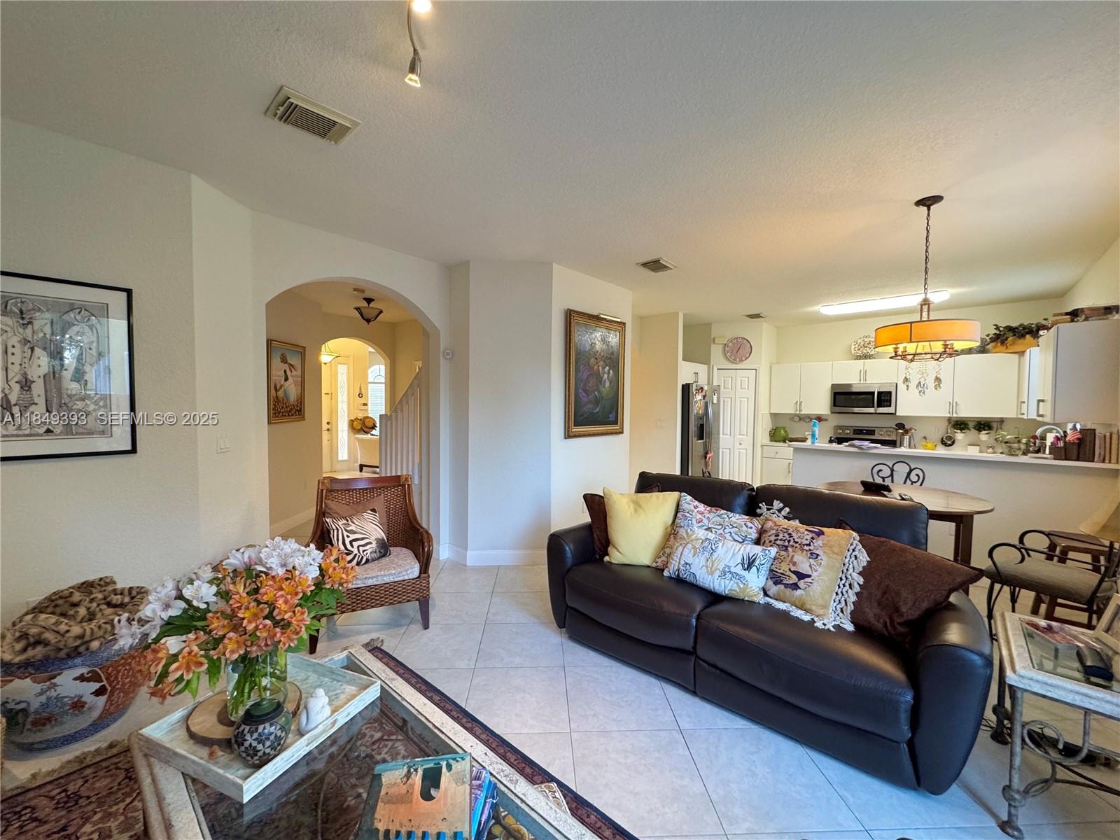11575 Southwest 138th Avenue Miami, FL 33186 - Photo 9 of 23 a living room with furniture and a chandelier