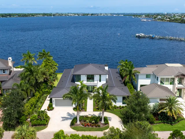 an aerial view of a house with a yard and lake view