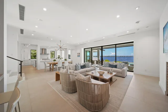 a large white kitchen with kitchen island a stove a sink a refrigerator and windows