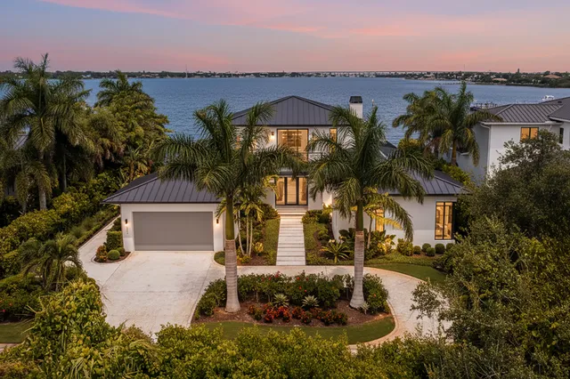 a view of swimming pool with lawn chairs and plants