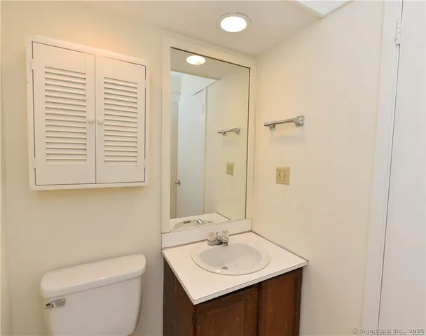 a bathroom with a sink a toilet and a mirror