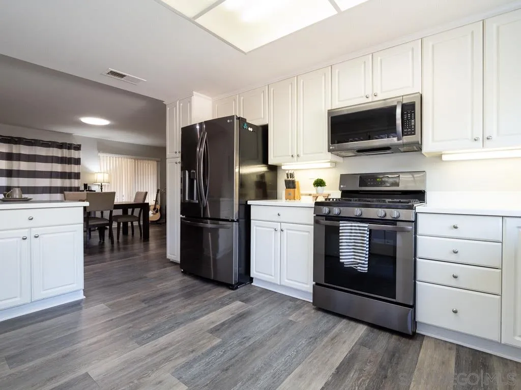 14018 Twin Peaks Road Poway, CA 92064 - Photo 1 of 27 a kitchen with a refrigerator stove and white cabinets