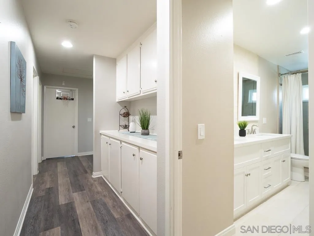 14018 Twin Peaks Road Poway, CA 92064 - Photo 20 of 27 a room with white cabinets and wooden floor