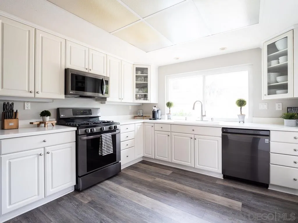 14018 Twin Peaks Road Poway, CA 92064 - Photo 2 of 27 a kitchen with granite countertop white cabinets and appliances