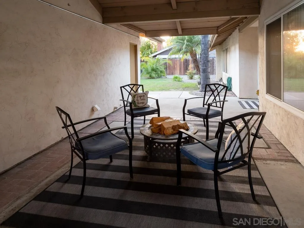 14018 Twin Peaks Road Poway, CA 92064 - Photo 21 of 27 a view of a patio with table and chairs under an umbrella with a small yard