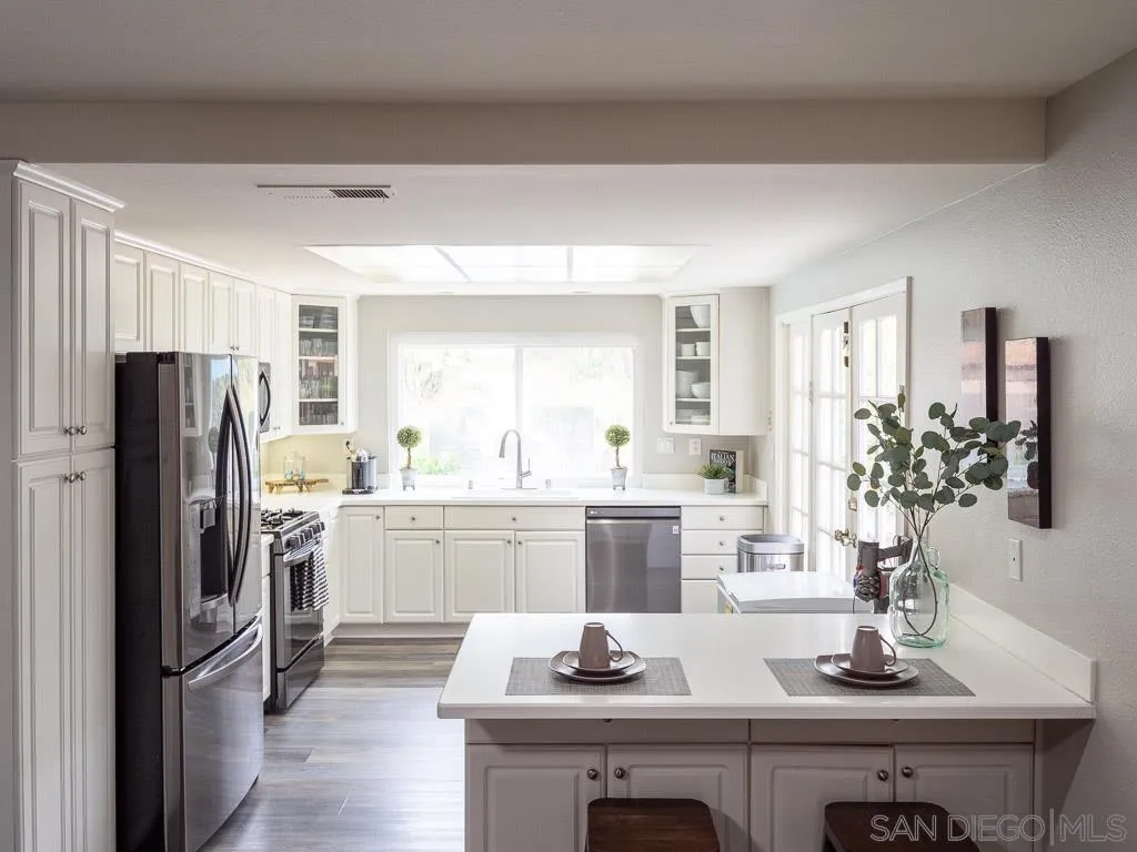 14018 Twin Peaks Road Poway, CA 92064 - Photo 3 of 27 a kitchen with refrigerator a sink and cabinets