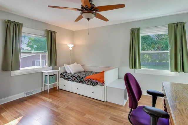 a bedroom with a bed and wooden floor