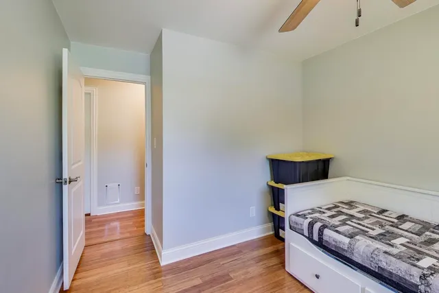 a bedroom with bed and wooden floor