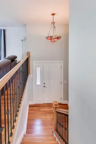 a view of a hallway with wooden floor and staircase