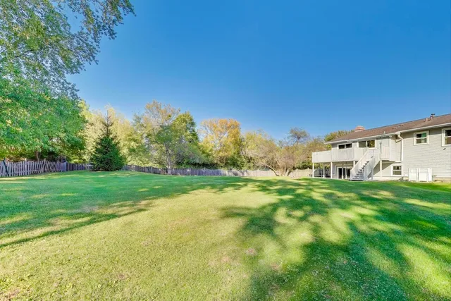 a backyard of a house with plants and large trees