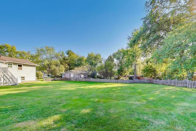 a backyard of a house with table and chairs