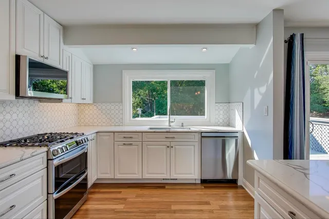 a kitchen with stainless steel appliances a stove sink and microwave