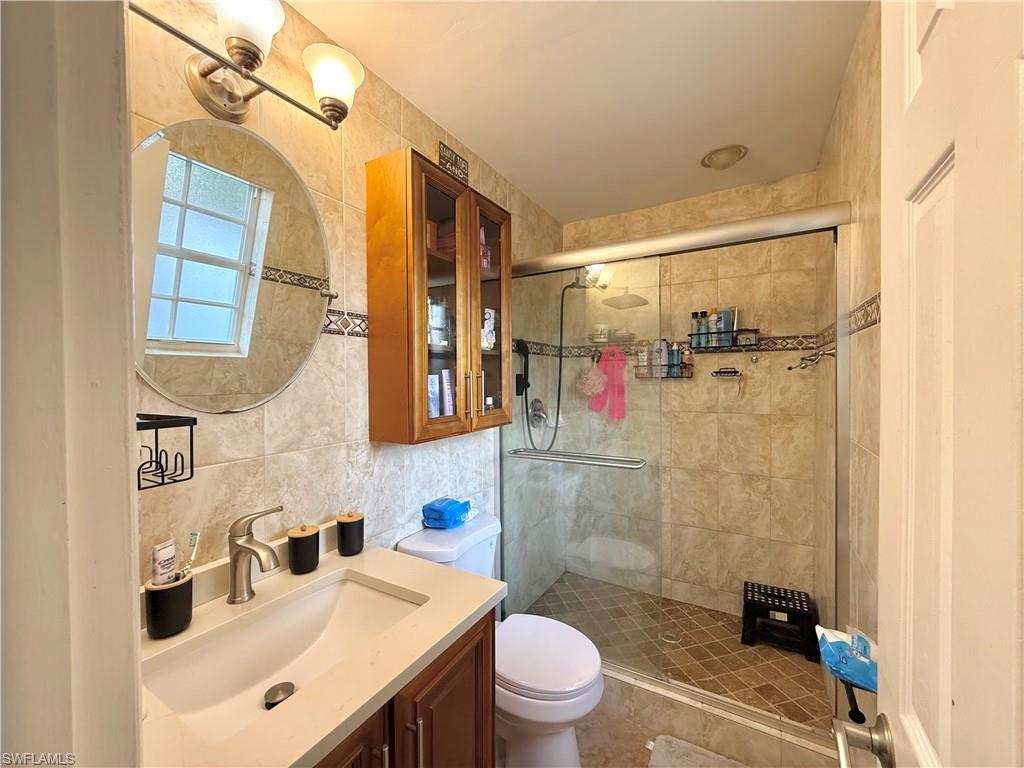 1964 42nd Street Southwest Naples, FL 34116 - Photo 14 of 25 a bathroom with a sink vanity mirror and toilet