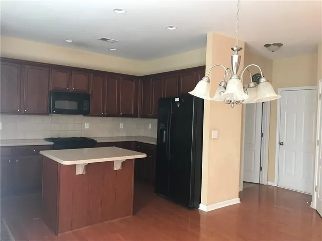 a kitchen with stainless steel appliances granite countertop a sink a stove a refrigerator and cabinets