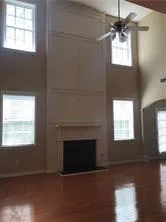 a view of empty room with fireplace and wooden floor