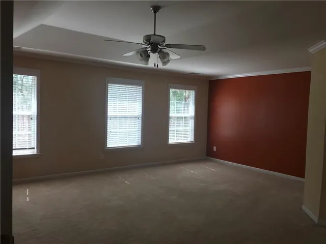 en empty room with windows and chandelier fan