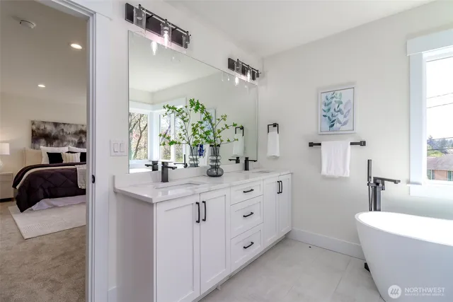 a bathroom with a double vanity sink a large mirror a bathtub and shower
