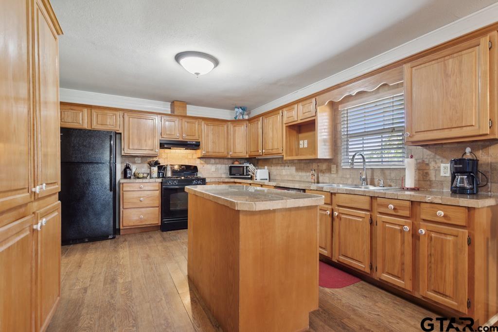301 Bascom Road Whitehouse, TX 75791 - Photo 16 of 31 a kitchen with stainless steel appliances granite countertop a refrigerator a sink dishwasher a stove with wooden cabinets and a granite counter top