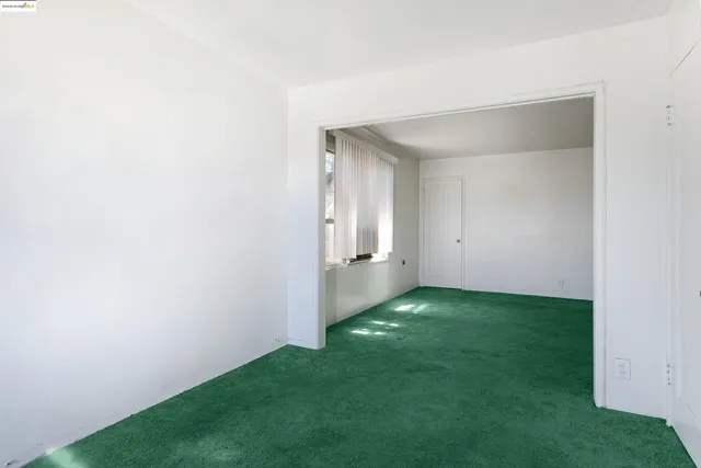 a view of an empty room with windows & cabinet