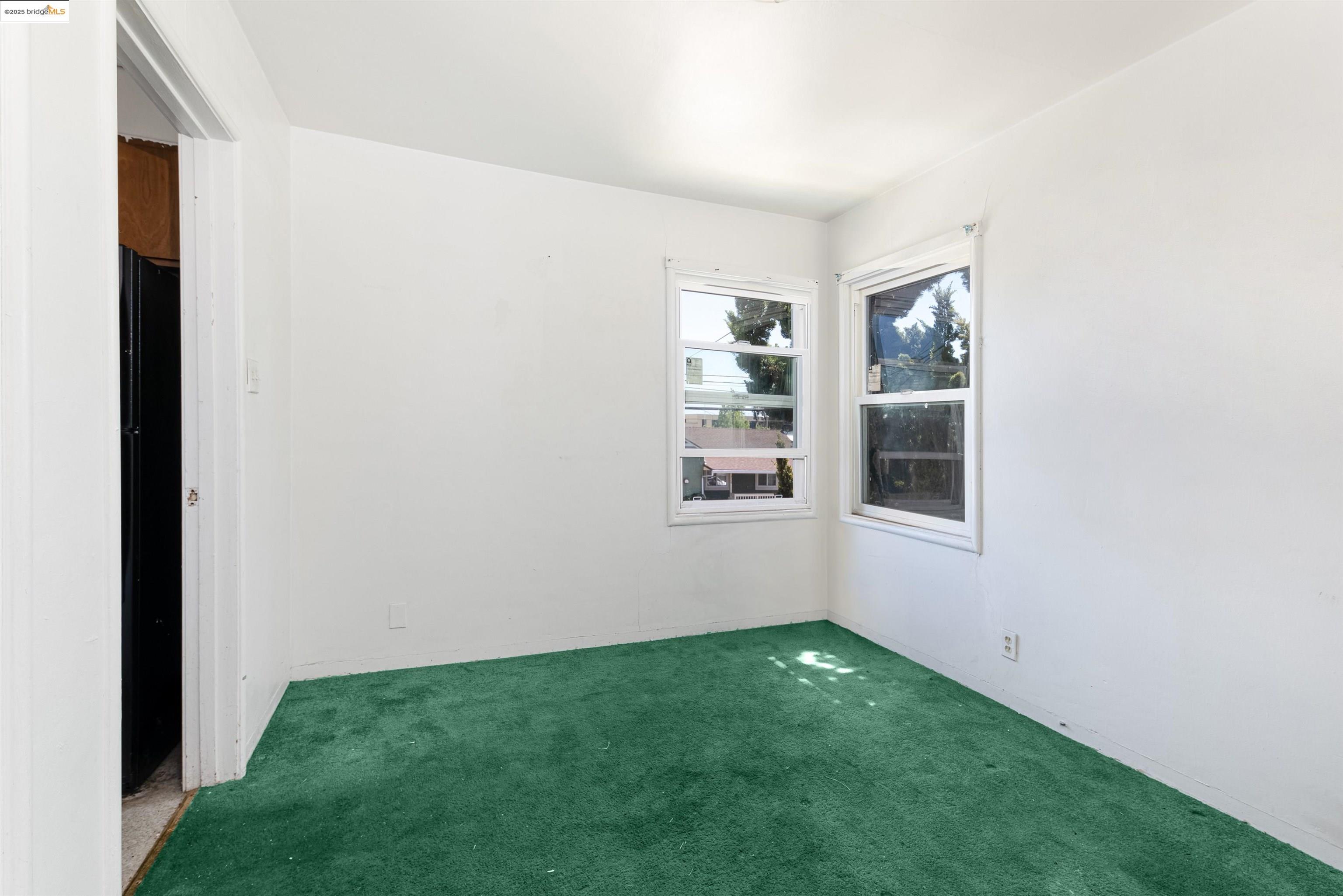 1427 65th Avenue Oakland, CA 94621 - Photo 7 of 13 a view of an empty room with windows & cabinet