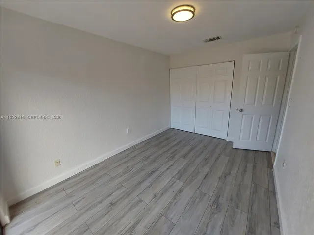 a view of a room with wooden floor