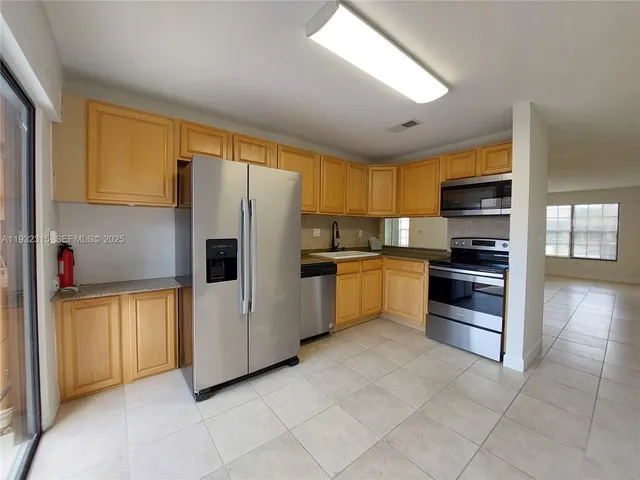 a kitchen with stainless steel appliances a refrigerator and a stove top oven