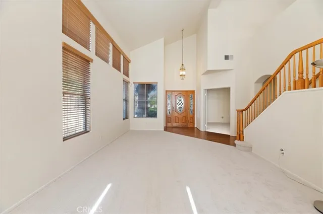 a view of an empty room with stairs and a window